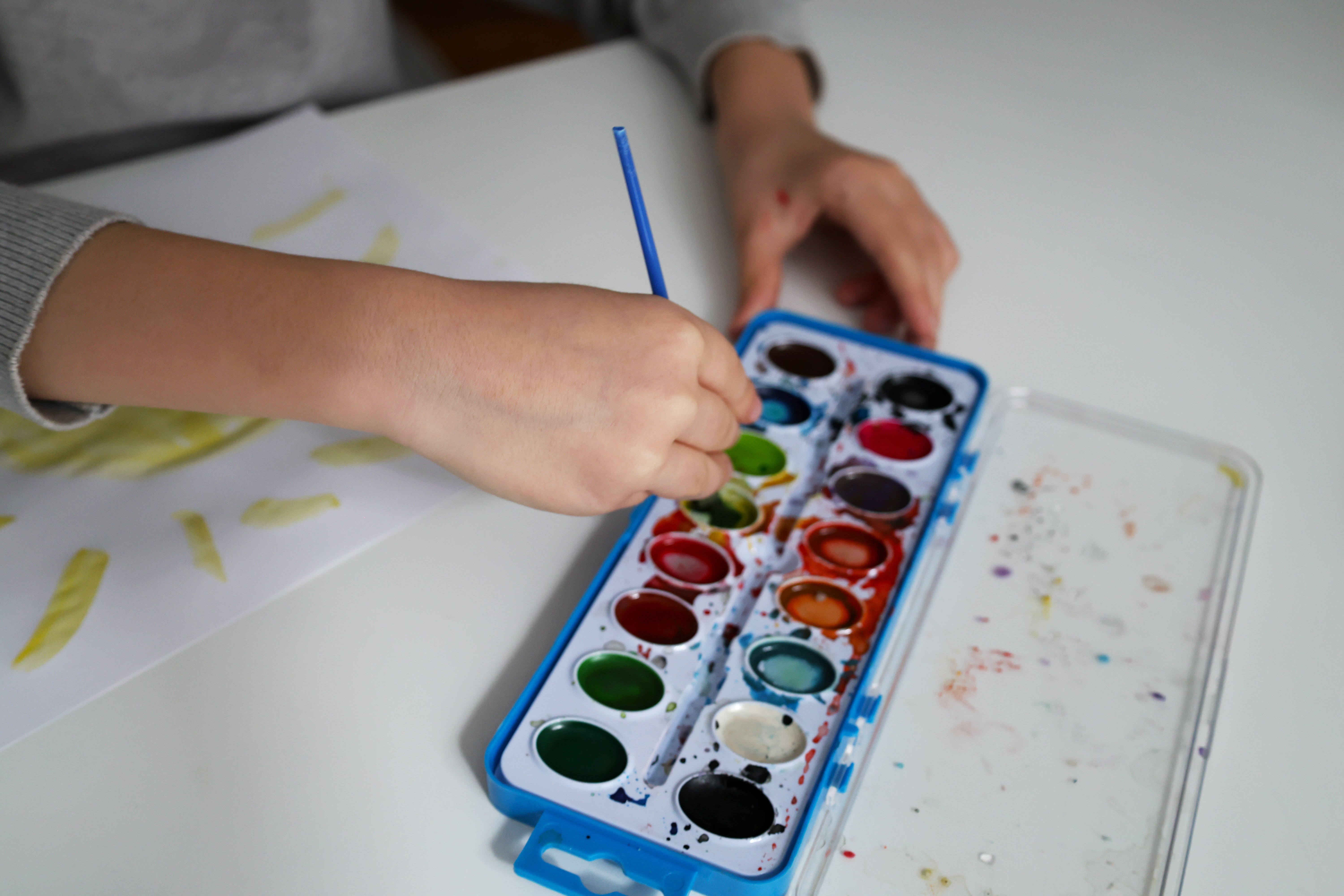 hands with watercolor paint tray